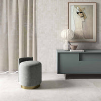 Modern interior with a gray sideboard, ottoman, and decorative items.
