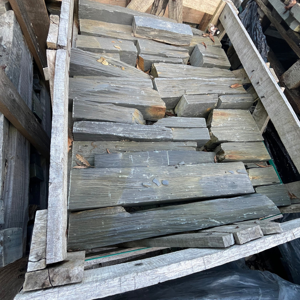 Stack of wooden planks on a pallet with a dark background