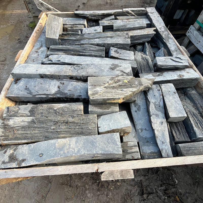 Stack of wooden planks on a pallet with a dark background