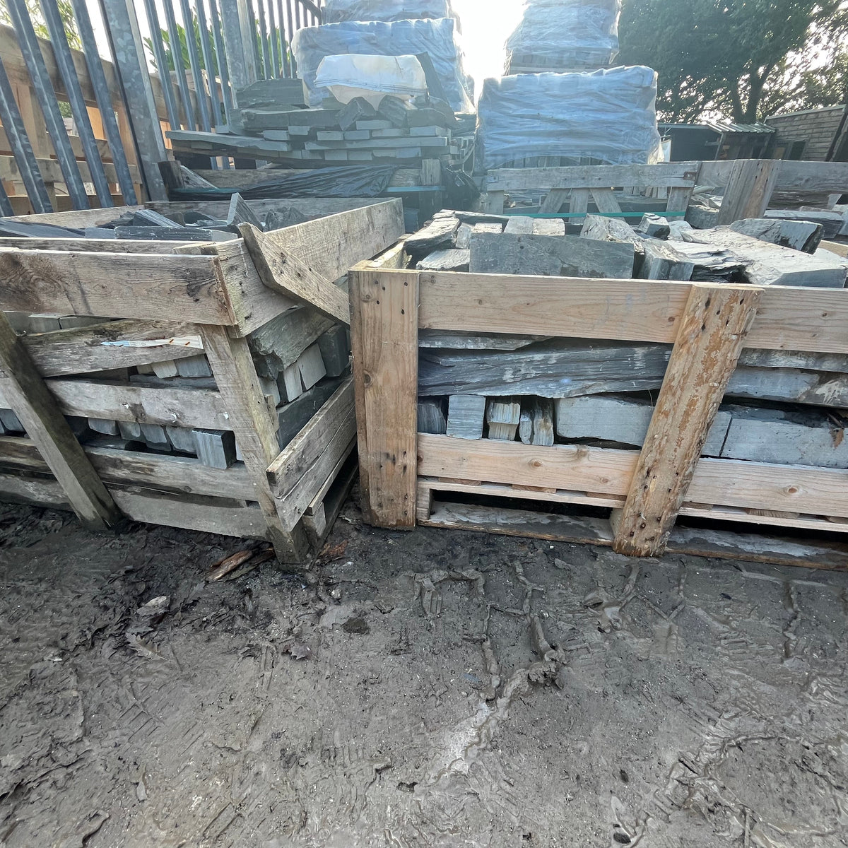Stacks of wooden crates with concrete blocks inside on a concrete floor.