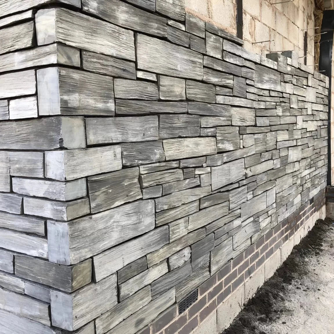 Decorative stone wall with a geometric pattern on a building exterior.