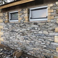 Stone wall with two windows on a building under construction