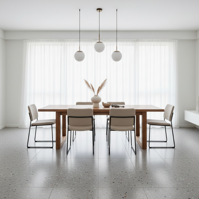 Modern dining room with a wooden table and chairs, featuring pendant lights and a vase.