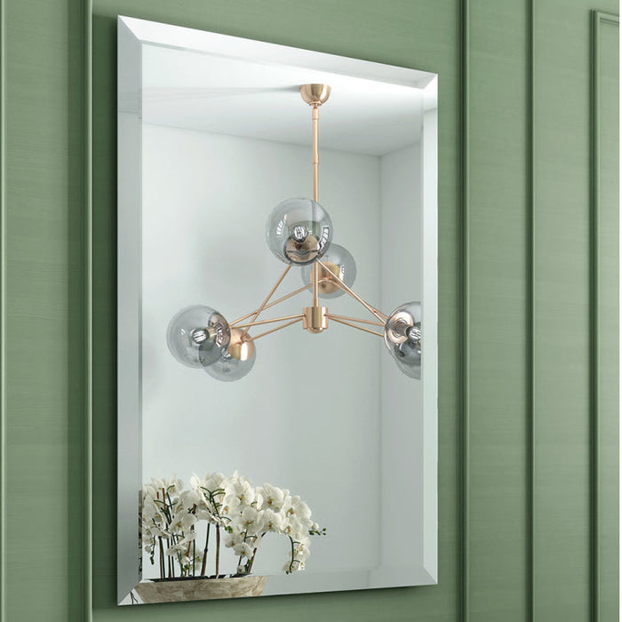 Bathroom with green paneling, black sink, and decorative mirror.