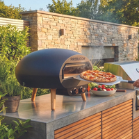 Man preparing pizza on an outdoor oven in a garden setting