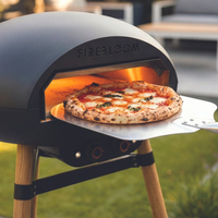 Firebloom outdoor pizza oven with a pizza inside, set against an outdoor background.