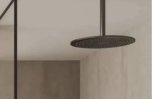 Black rainfall shower and glass screen in a stone-tiled wetroom